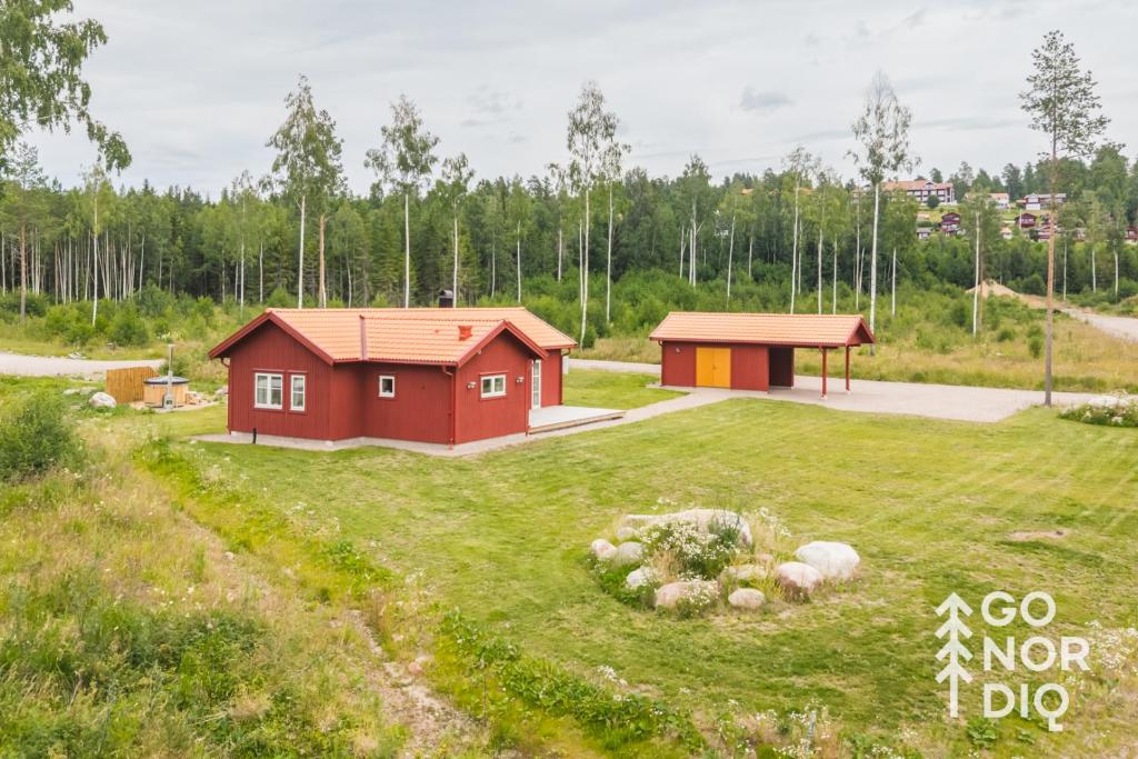 a small red house in a grassy field at The Red Deer Lodge in Tällberg
