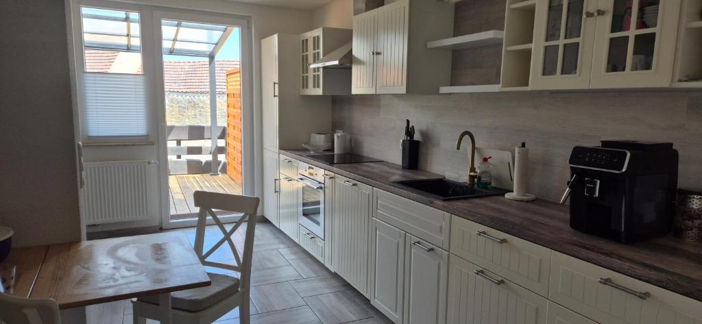 a kitchen with white cabinets and a wooden counter top at Lindenplatz 6 in Sondershausen