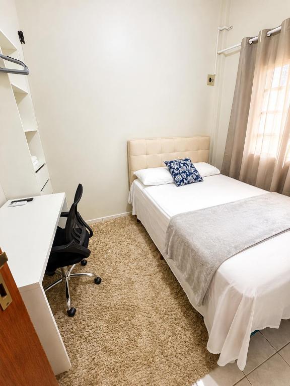 a bedroom with a bed and a desk and a chair at Apartamento no Centro da Cidade Nova in Marabá