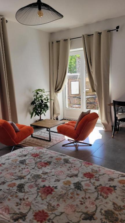 a living room with orange chairs and a rug at studio douillet en centre bourg in La Plaine-sur-Mer