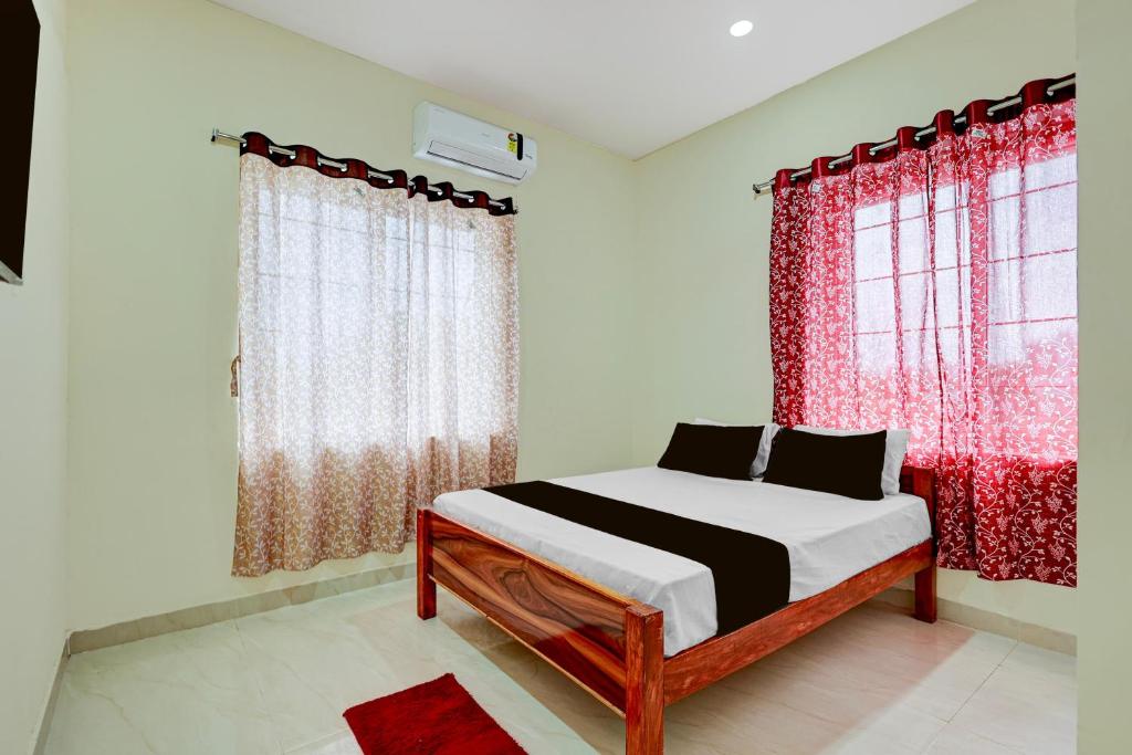 a bedroom with a bed with red curtains at SPOT ON Deepla Grand in Warangal