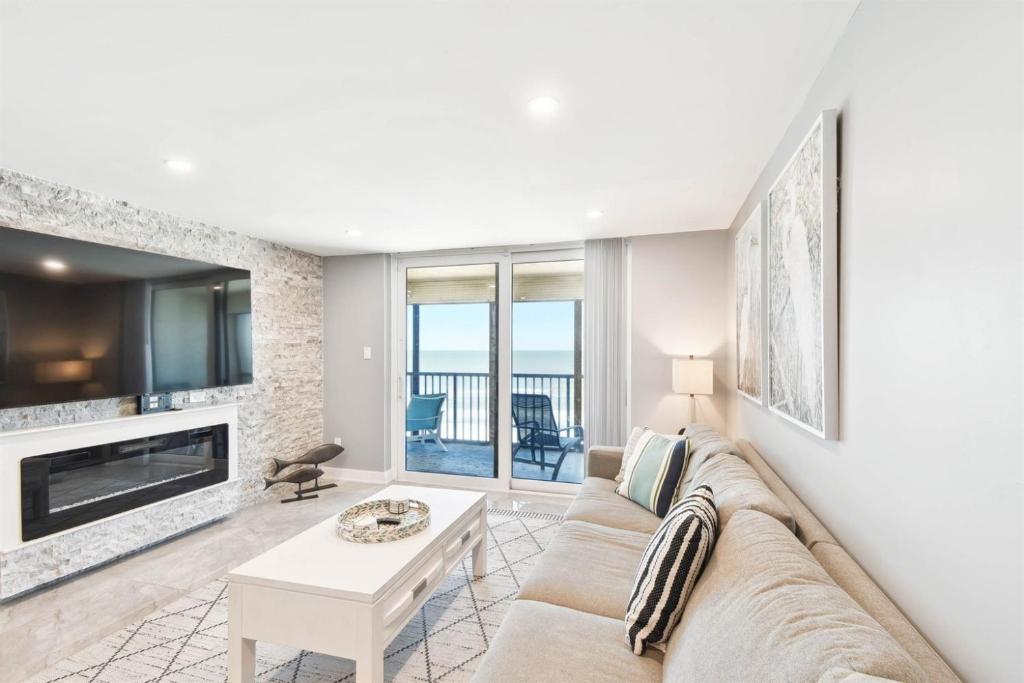 a living room with a couch and a fireplace at Luxury Oceanfront Penthouse Condo in Clearwater Beach