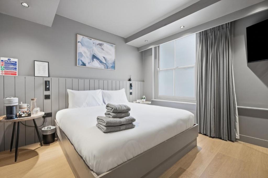 a bedroom with a bed with towels on it at The Maida Hotel in London