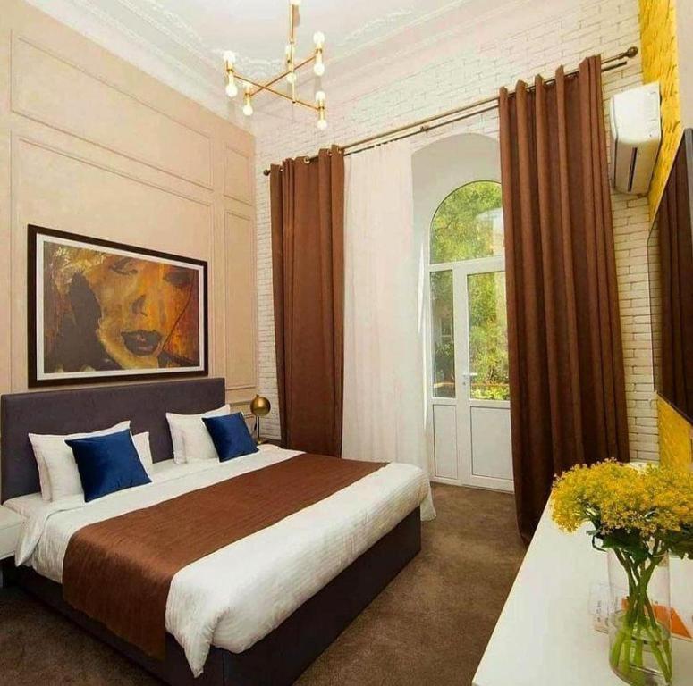 ein Schlafzimmer mit einem großen Bett und einem Fenster in der Unterkunft ZM hotel in Baku