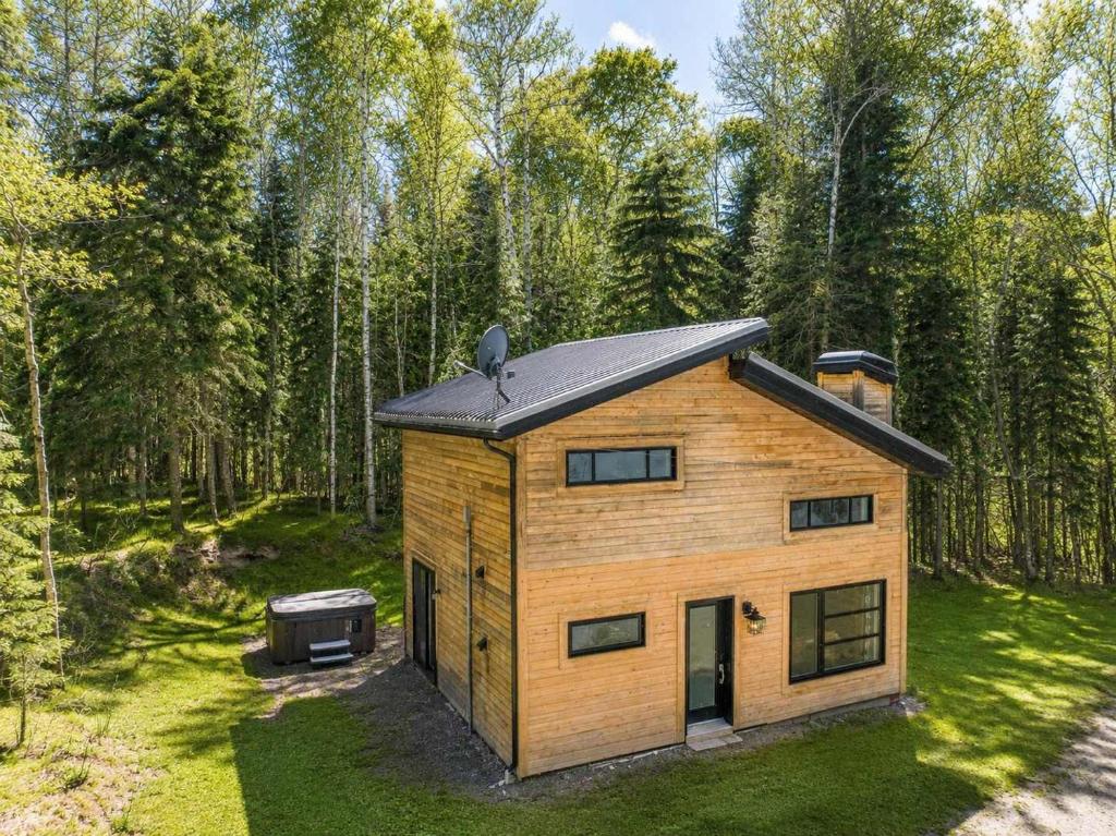 a tiny house in the woods with a grill at Chalet Chic et Spa - St-Come in Saint Come