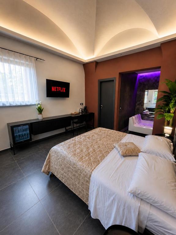 a bedroom with a bed and a tv on the wall at Il Casale del 900 in Catania