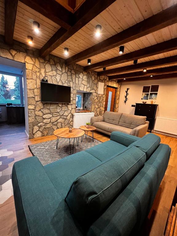 a living room with a couch and a stone wall at Mount House Mavrovo in Mavrovo