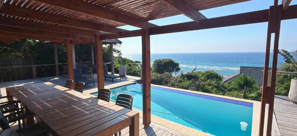 a view of a swimming pool and the ocean at Makana 3A in Ponta Mamoli