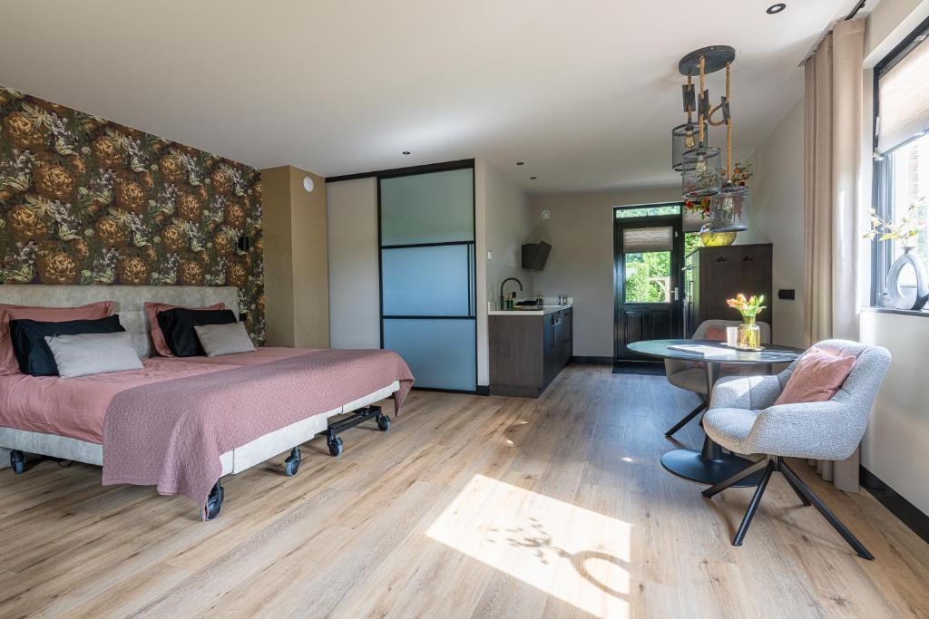 a bedroom with a bed and a table and a chair at Bij Corine, bed en zorg in Altforst