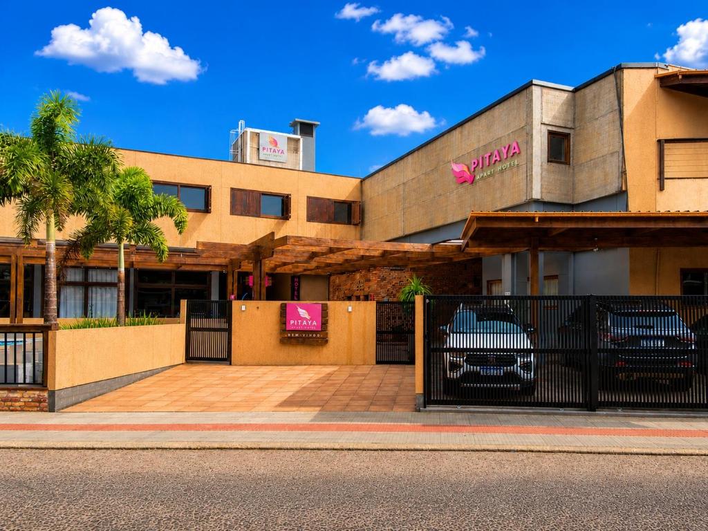a building with a fence in front of it at Pitaya Apart Hotel in Garopaba