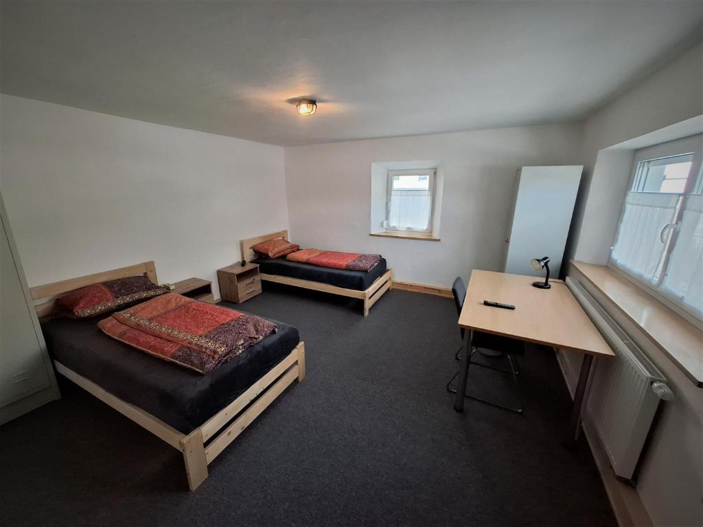 a room with two beds and a desk in it at Zum oid'n Leidlhof in Berching