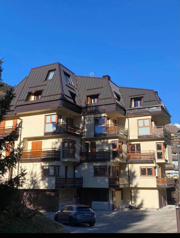 a large apartment building with a metal roof at Appartamento Lisander in Ponte di Legno