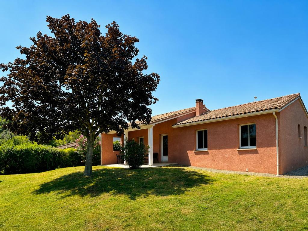 a brick house with a tree in the yard at Maison Mirepoix 100m2 in Mirepoix