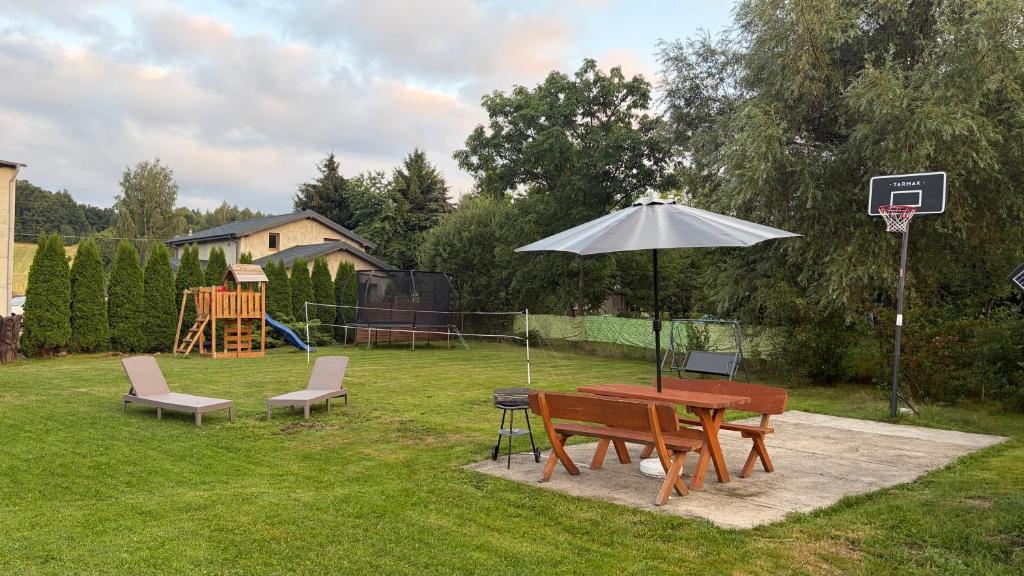a picnic table and an umbrella in a backyard at Chata na Karpackiej in Kostrzyca