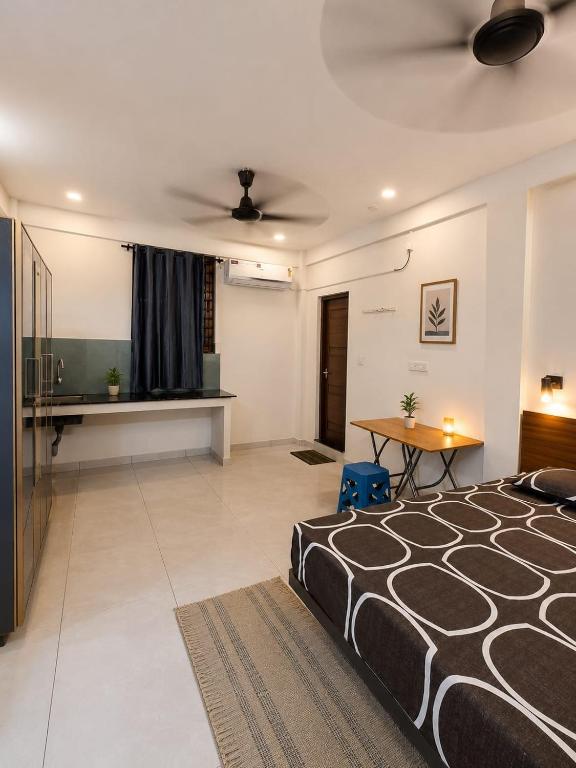 a bedroom with a black and white bed and a table at K K Residency in Alwaye