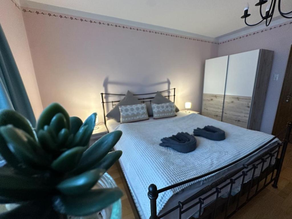 a bedroom with a bed with blue sheets and a plant at Max and Moritz Top 9 in Liebenau