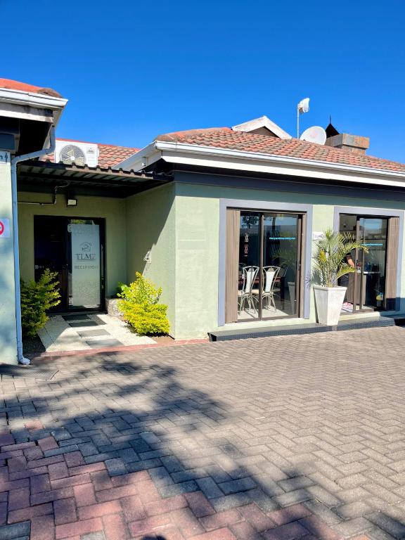 a house with a brick driveway in front of it at TLMZ Guesthouse in Newcastle