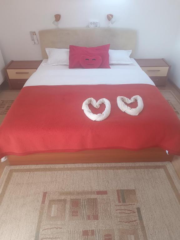 a bedroom with a bed with two heart towels on it at Pasager House in Sovata