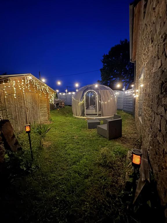 a large dome tent in a yard at night at la bulle d'Astrée in Le Tronchet