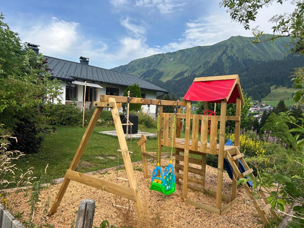 a wooden playground with a swing set in a yard at Mazot Ferienhaus Kleinwalsertal in Riezlern