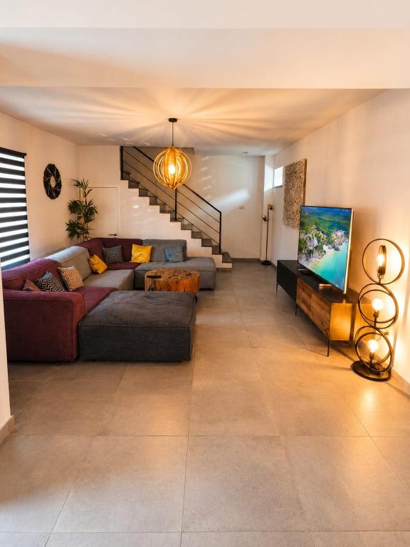 a large living room with a couch and a tv at Escale Tout Confort Maison entière Parking gratuit Proche Aéroport Charleroi in Charleroi
