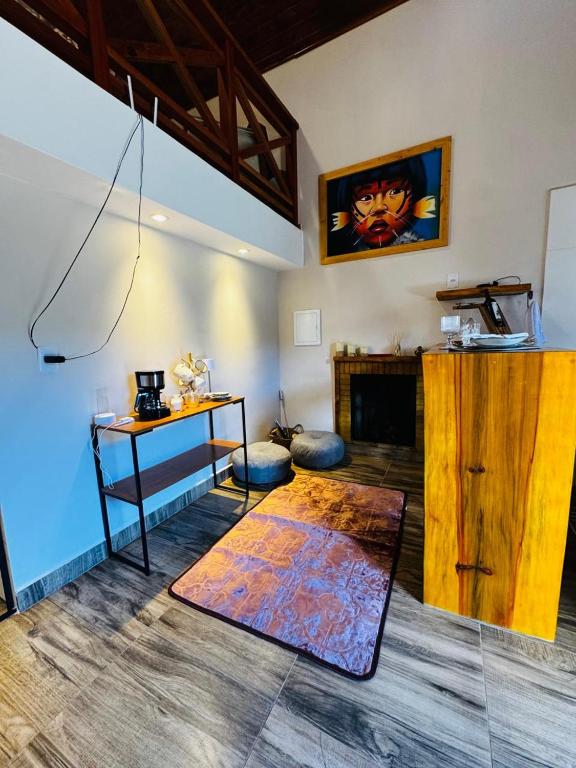 a living room with a table and a fireplace at Chalé Recanto Figueira in Camanducaia