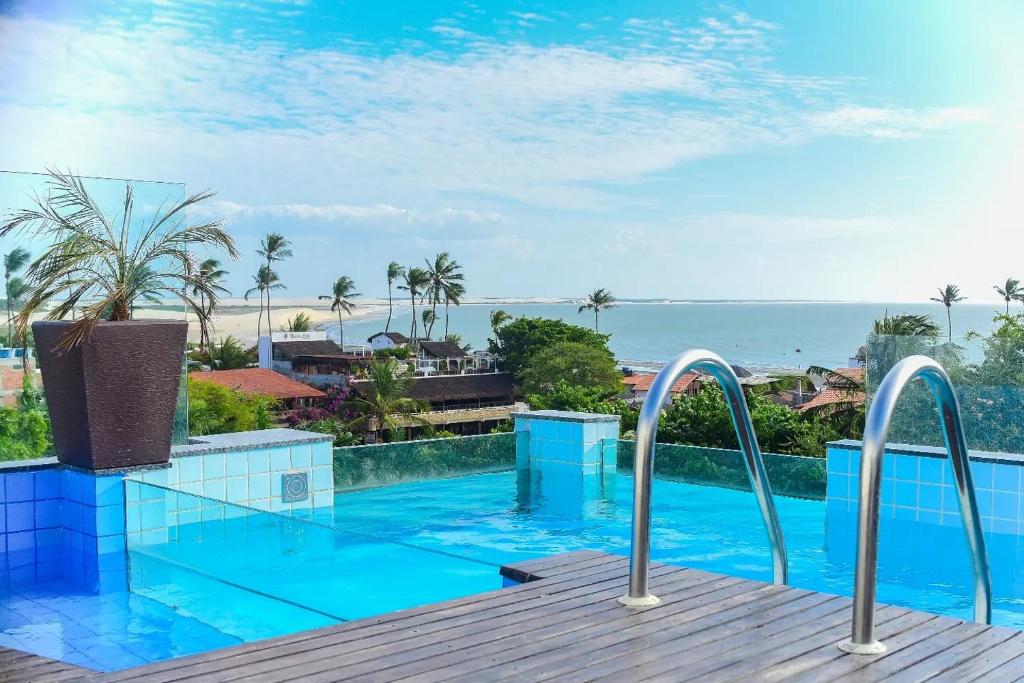 a swimming pool with a view of the ocean at Beleleus Jeri in Jericoacoara