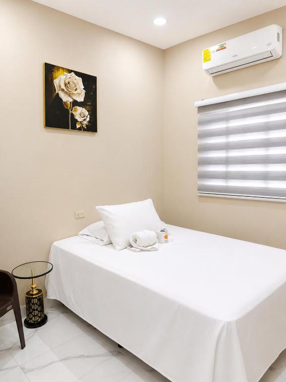 a bedroom with a white bed and a window at Hotel Castillo in San Pedro Sula