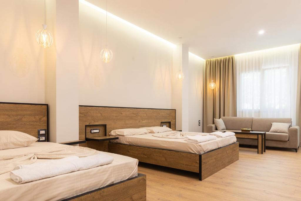 a hotel room with two beds and a couch at Ambra & Arber Hotel in Bogovë