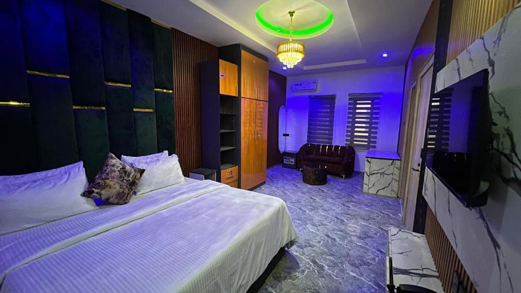 a bedroom with a bed and a tv in it at Oak Haven Lodging & Suites in Sagamu