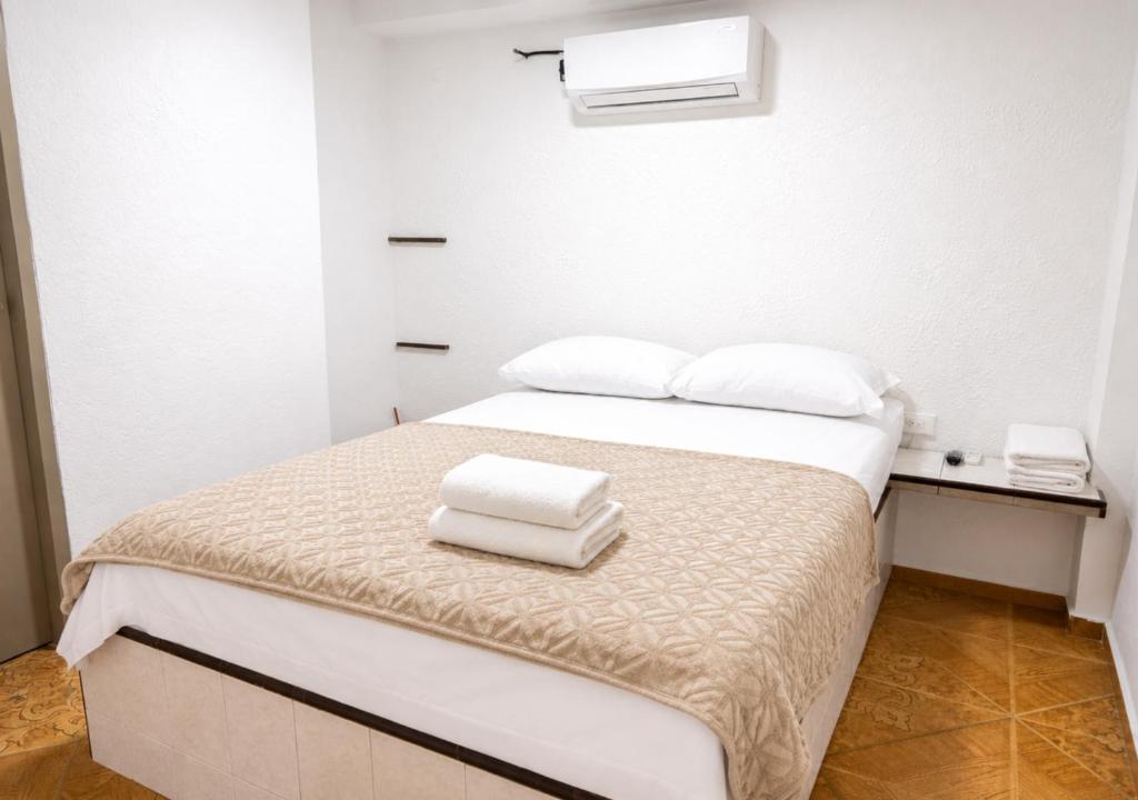 a bedroom with a bed with two towels on it at O C E A N B L U E Hotel Bahia in Santa Marta