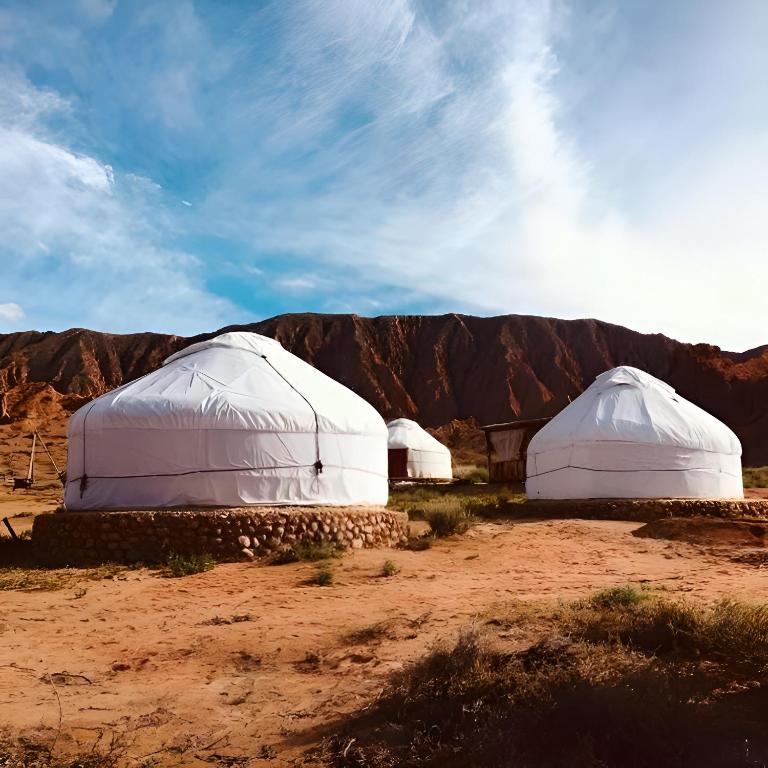 two domes in the desert with mountains in the background at Mars Canyon Yurt Camp in Tong