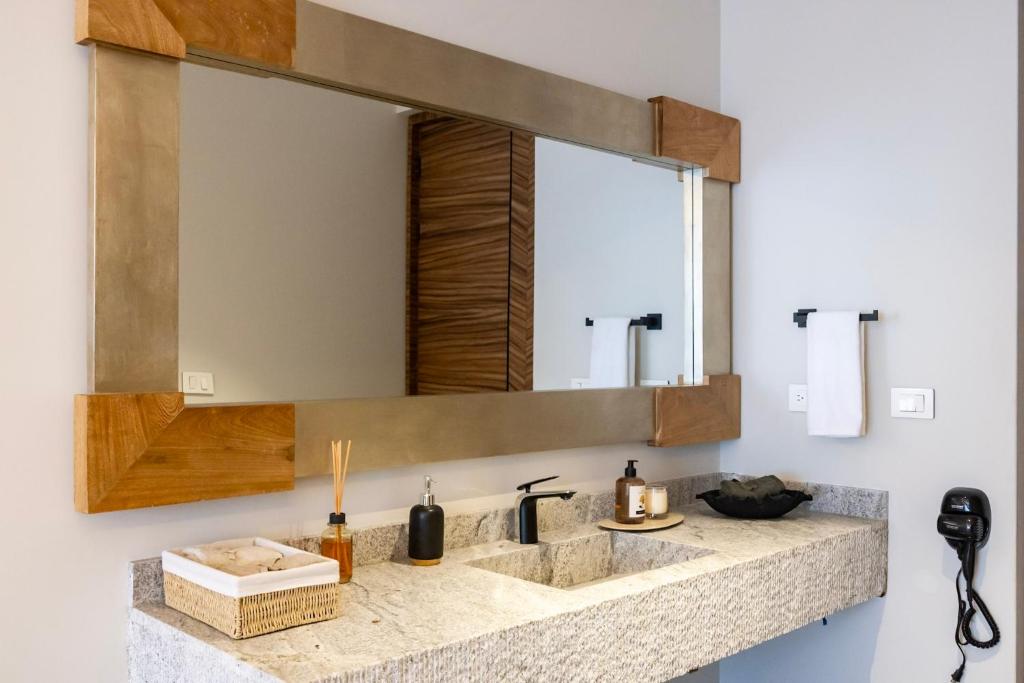 a bathroom with two sinks and a mirror at Hotel Alma Boutique in Jiutepec