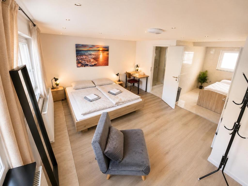 a bedroom with a bed and a chair in a room at City Apart 3 nahe Badewelt, Museum & Bahnhof mit NETFLIX in Sinsheim