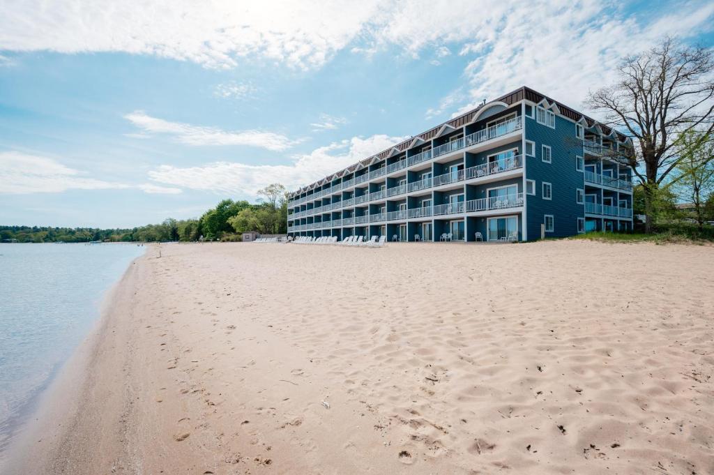 a building on the beach next to the water at Bayshore Resort in Traverse City