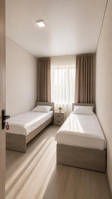 a bedroom with two beds and a window at Золотые пески in Bosteri