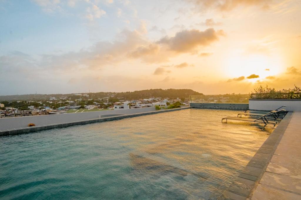 ein Swimmingpool auf dem Dach eines Gebäudes mit dem Sonnenuntergang in der Unterkunft Zapadilly Tree Hotel in San Andrés