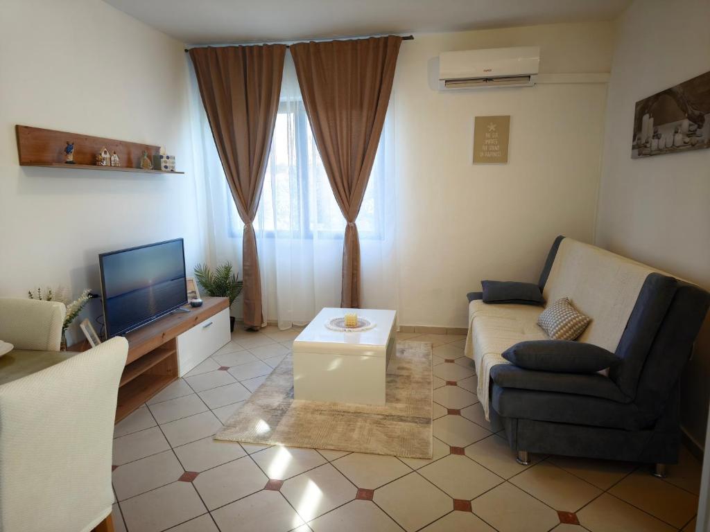 a living room with a couch and a tv at Apartman Ivona in Zadar