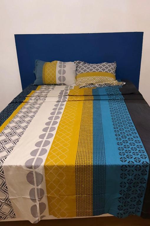 a bed with a colorful comforter and pillows on it at La Villa La ri Deye in Kourou