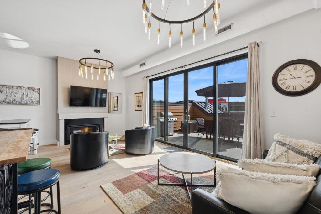 a living room with a fireplace and a clock on the wall at Alpenglow Retreat in Whitefish