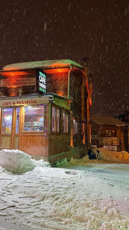 a building on the side of a street in the snow at Abduloğlu Butik Otel in Ayder Yaylasi