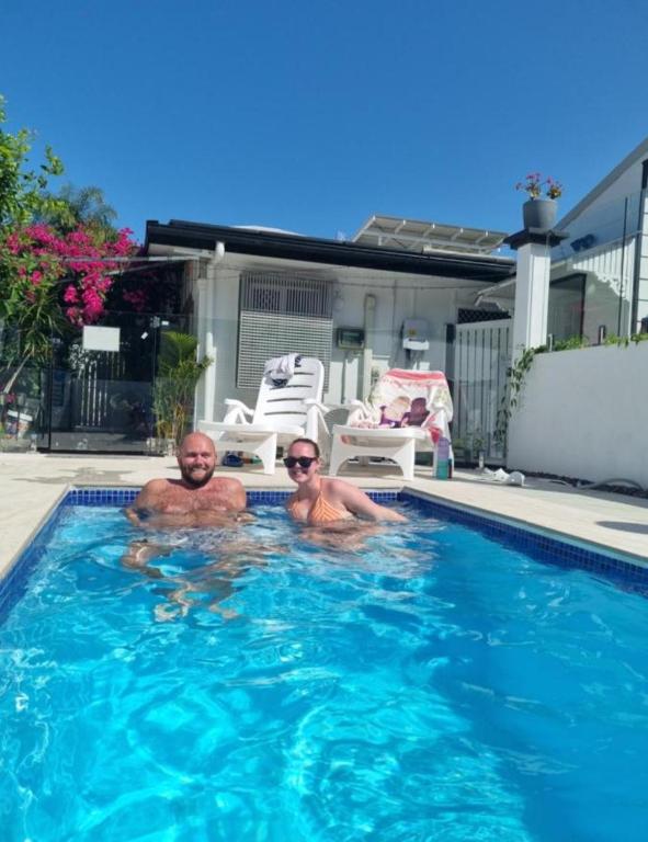 a man and a woman in a swimming pool at Backpackers Homestay 21-36 yrs ONLY in Caloundra