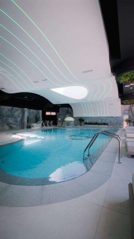 a large swimming pool with blue water in a building at Motel Predejane in Predejane