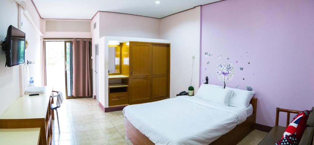 Schlafzimmer mit einem weißen Bett und einem TV in der Unterkunft บ้านภูมิพันธ์ in Hat Yai