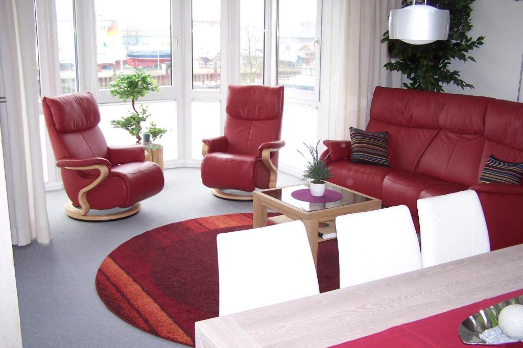 ein Wohnzimmer mit roten Stühlen und einer roten Couch in der Unterkunft Marina 38-2 in Cuxhaven
