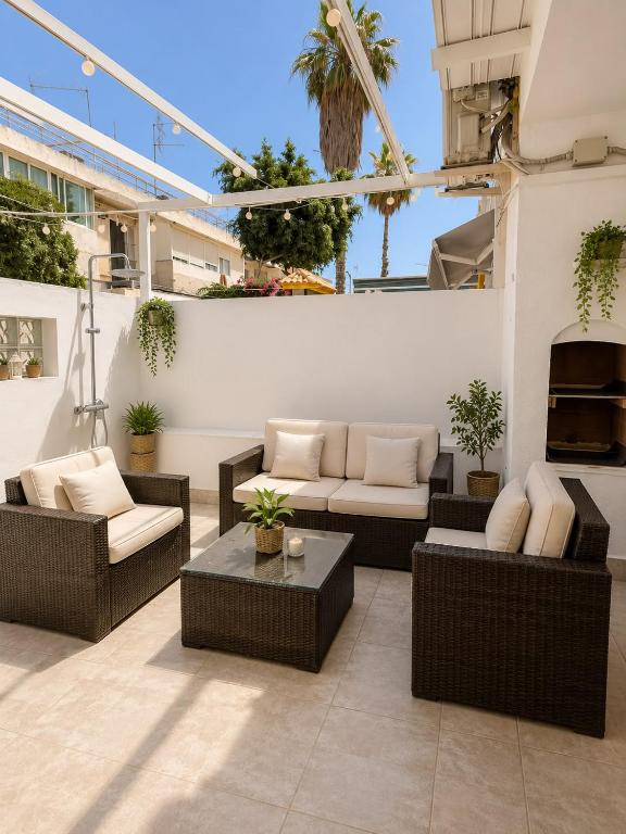 an outdoor patio with couches and a table at Little Los Emilios in Torrevieja