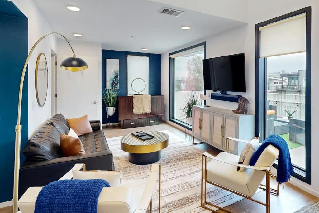 a living room with a couch and a tv at Illume 407 in Nashville