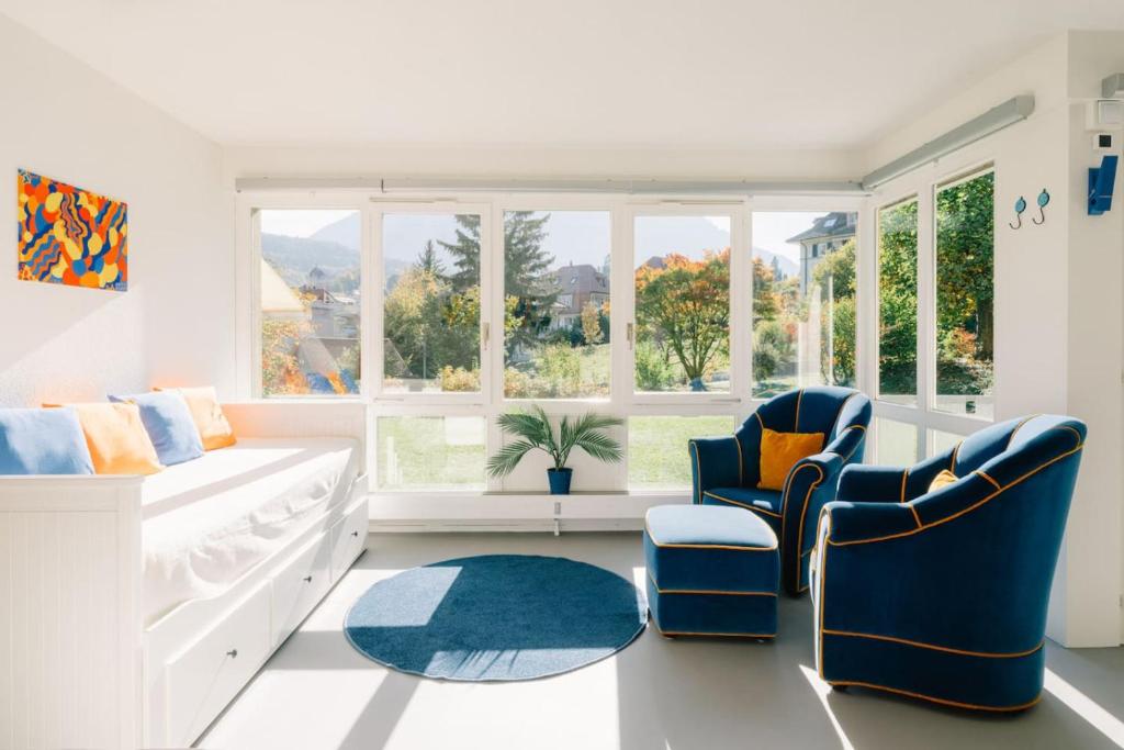 a living room with two chairs and a couch at Apartment Baytrail in See- und Bergnähe, modern, mit Garten, 4 Gäste in Spiez