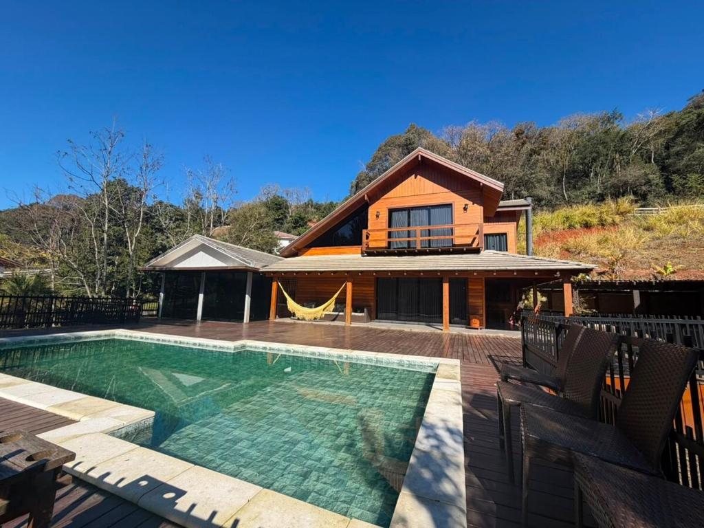 a house with a swimming pool in front of a house at Cabanha Tessaro in Chapecó