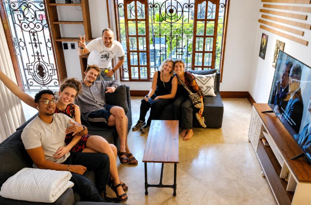 a group of people sitting in a living room at Paisa Hostel Medellín in Medellín